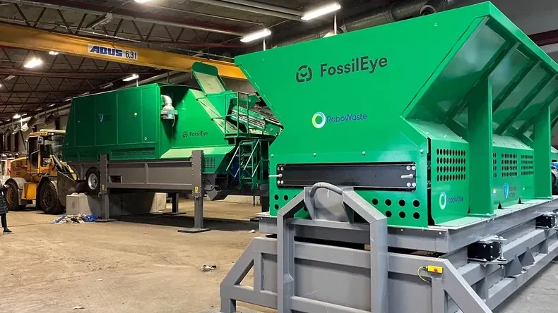 The two FossilEye machines in a hall, green with the RoboWaste logo